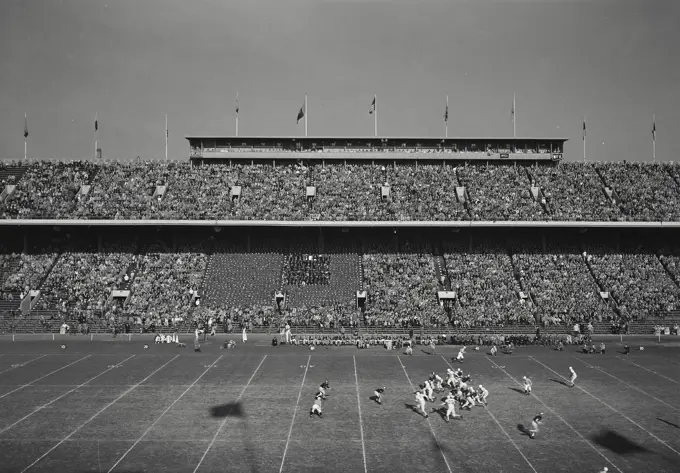 Vintage Photograph. Large football game with fans filling stands. Frame 2