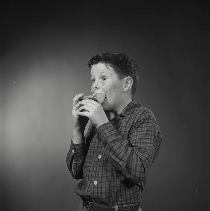 Vintage Photograph. Boy eating slice of pie with hands. Frame 1