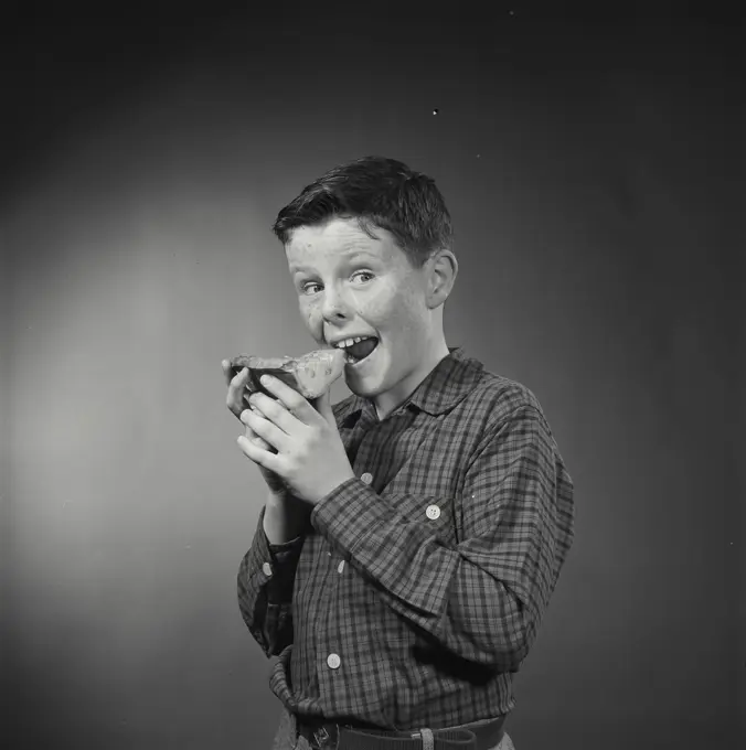 Vintage Photograph. Boy eating slice of pie with hands. Frame 2