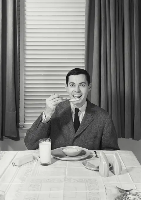 Vintage Photograph. Man in suit eating oatmeal. Frame 1