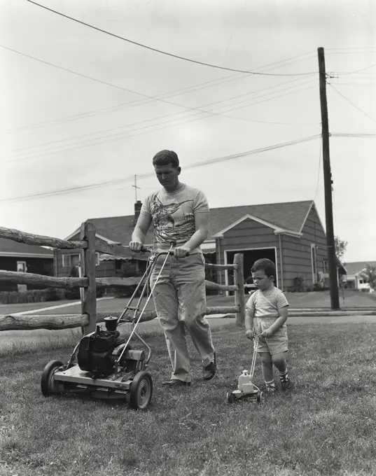 Vintage Photograph. Father mowing lawn with power mower as son walks alongside with toy mower Frame 2