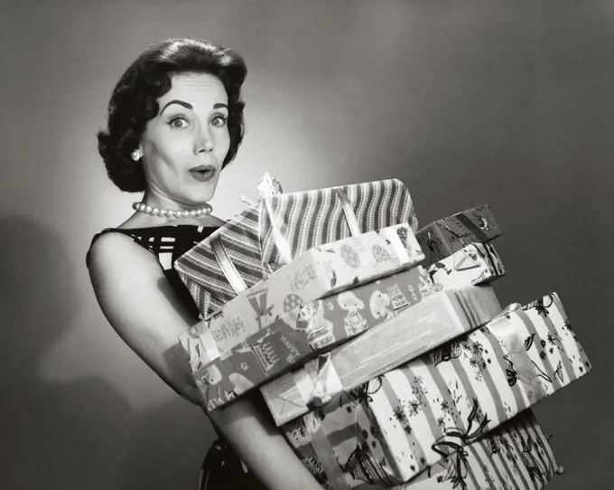 Close-up of a mid adult woman carrying a stack of gifts