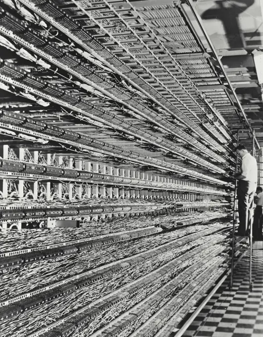 Vintage photograph. Technicians working on a distributing frame in a telephone network control room