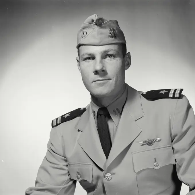 Vintage Photograph. Soldier in formal wear poses in studio portrait.