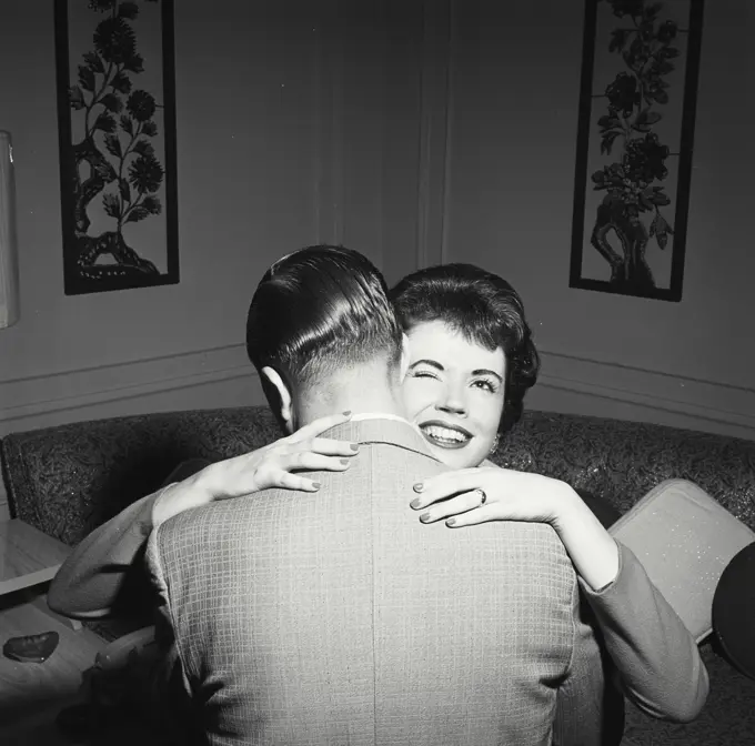 Vintage Photograph. Woman winking at camera while hugging man. Frame 2