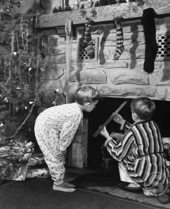 Two boys peeping into a fireplace