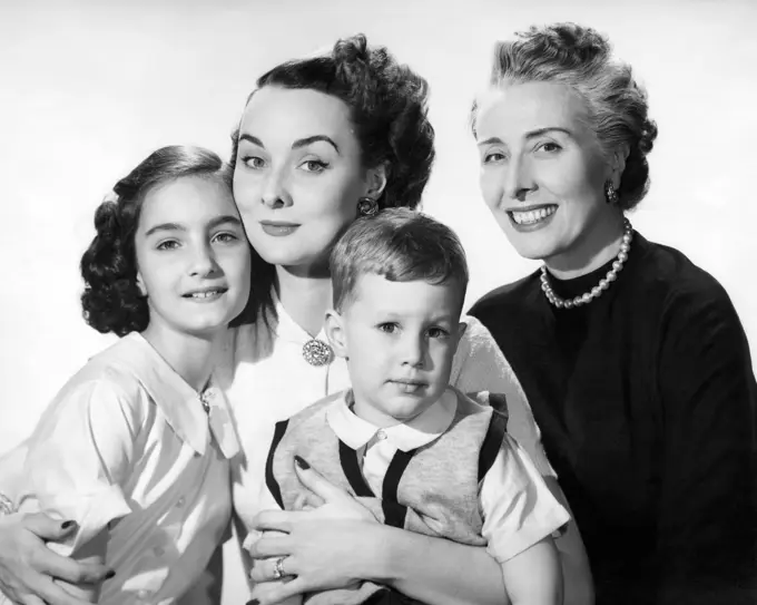 Portrait of a grandmother smiling with her daughter and two grandchildren