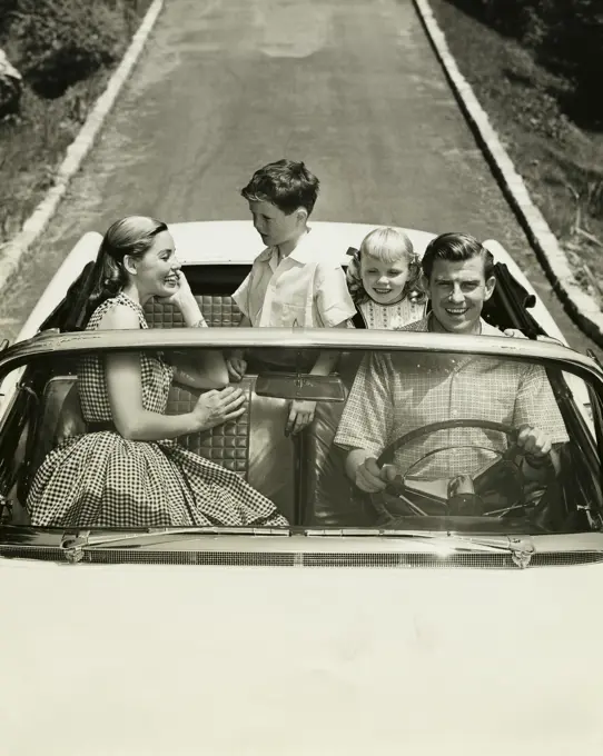 High angle view of parents and their children traveling in a car