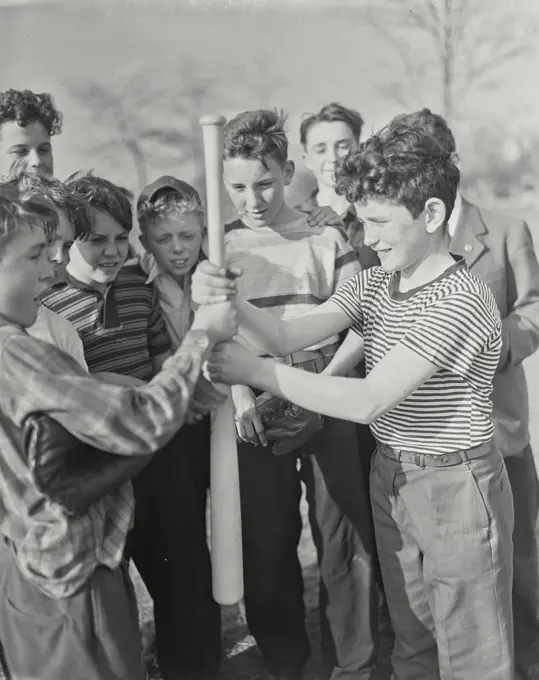 Vintage photograph. Side profile of two boys holding a baseball bat