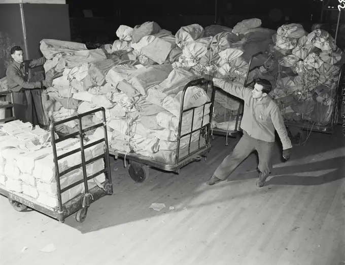 Vintage photograph. New York General Post Office. Transporting made up sacks on nutting trucks for dispatch.