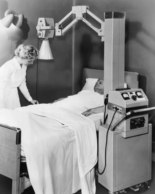 Female nurse adjusting the sheet of a patient in an X-Ray room