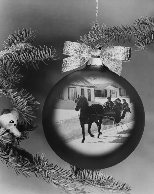 Close-up of a horsedrawn sleigh superimposed on a Christmas ornament