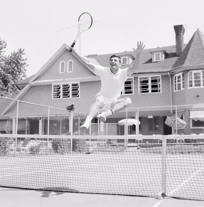 Happy man jumping when playing tennis