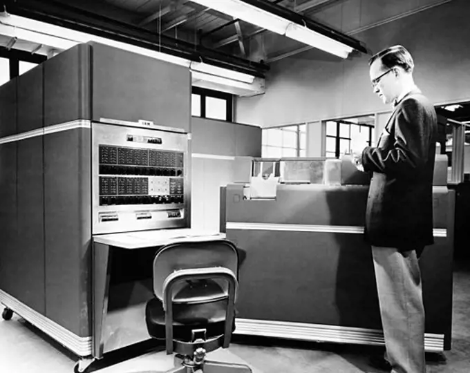 Side profile of a technician standing in front of a computer