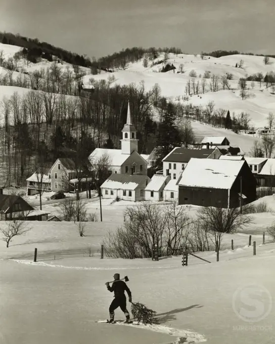 High angle view of a man pulling a Christmas tree on a snow covered landscape