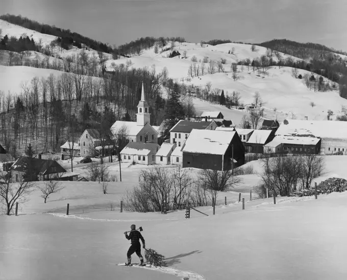 High angle view of a man pulling a Christmas tree on snow