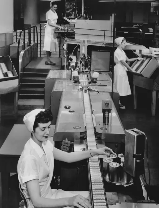 Female workers working on an automatic packaging machine, Rochester, New York State, USA