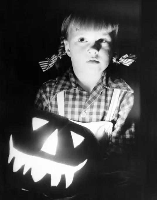 Close-up of a girl with illuminated jack o' lantern