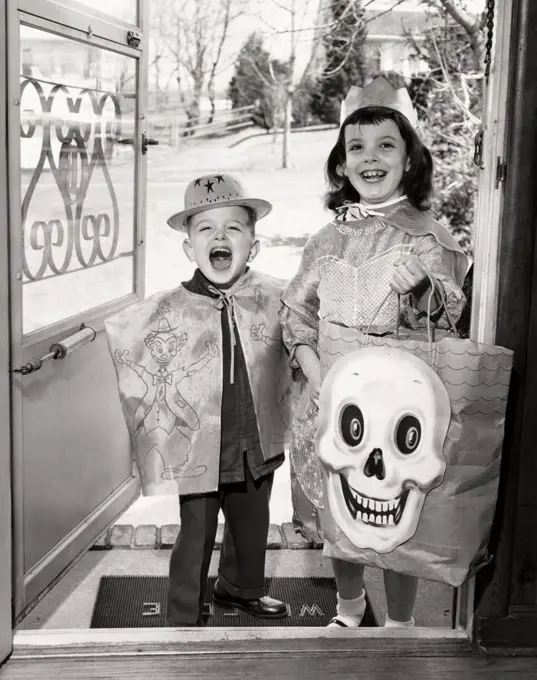 Portrait of a boy and a girl wearing Halloween costumes for trick or treating