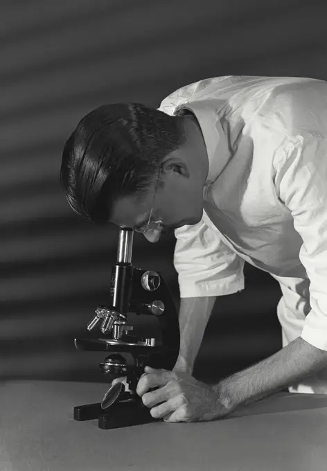 Vintage Photograph. Close-up of a scientist looking through a microscope