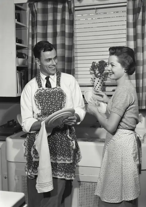 Vintage Photograph. Husand wearing wife's apron in kitchen. Frame 3