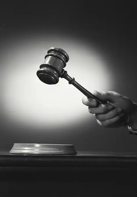 Vintage photograph. Close-up of a person's hand holding a gavel