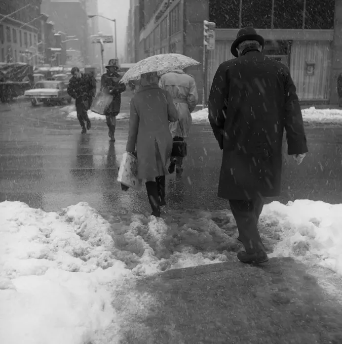 USA, New York City,  pedestrians walking through snow