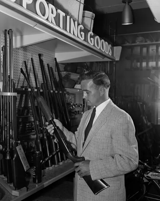 Man choosing airgun in shop