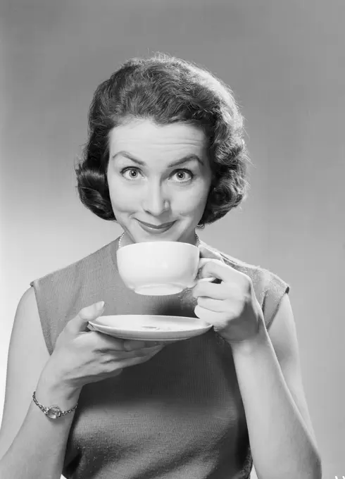 Studio portrait of mid adult woman drinking tea