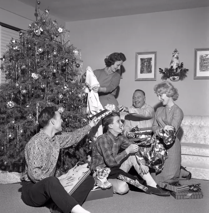 Family opening christmas gifts around Christmas tree