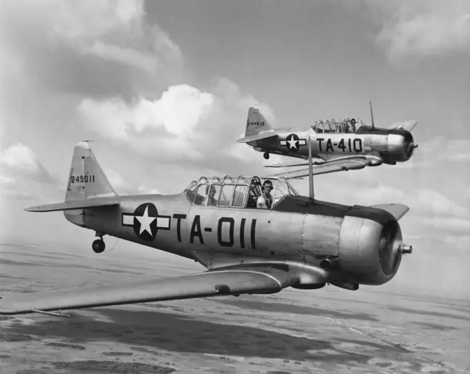 Side profile of two fighter planes in flight, AT-6 Texan