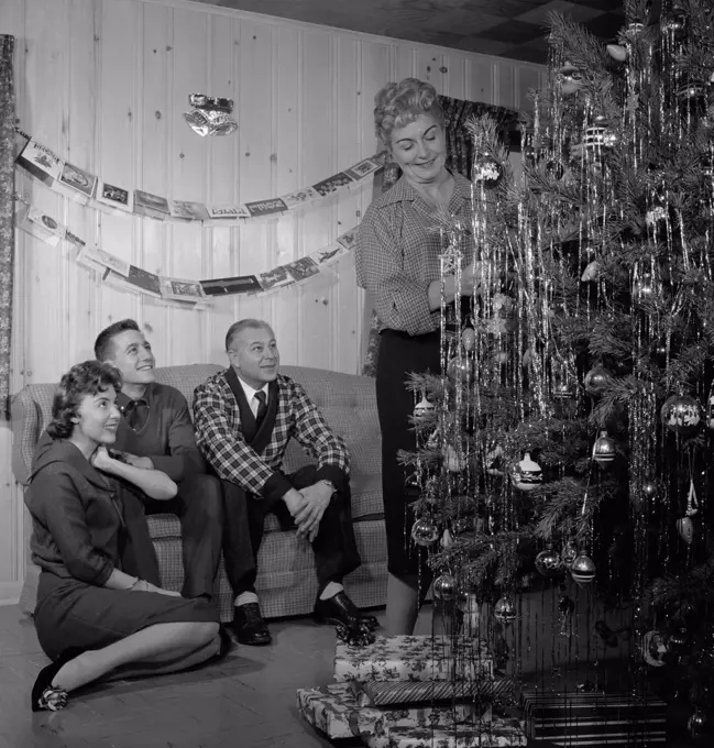 Family preparing Christmas tree in living room