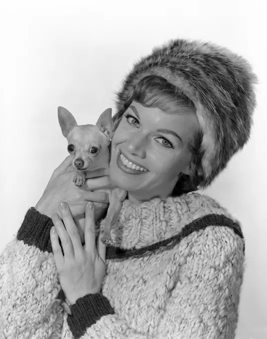 Studio portrait of young woman embracing dog