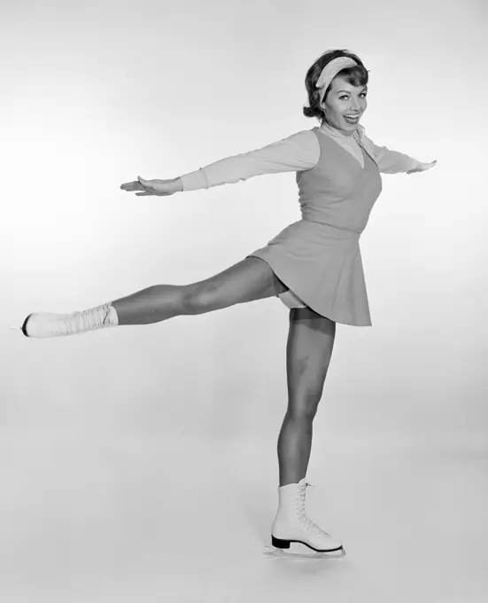 Studio portrait of young woman ice skating