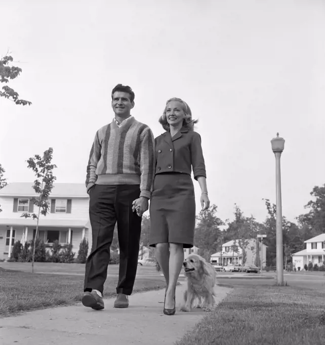 Mid-adult couple walking with dog