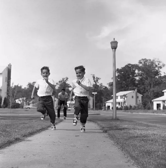 Twin boys running on pavement