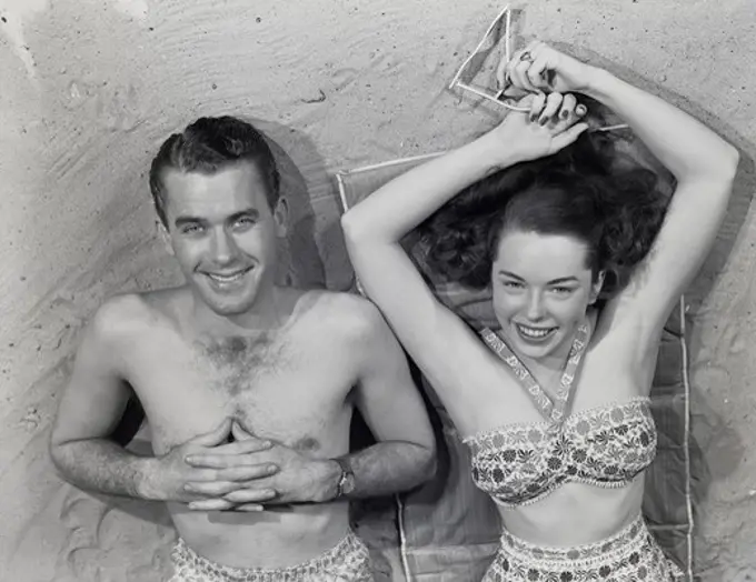 Overhead portrait of young couple relaxing on beach