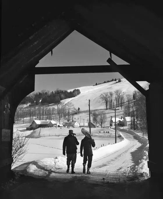 USA, New England, Vermont, Turnbridge, Men walking under covered bridge on Route 110