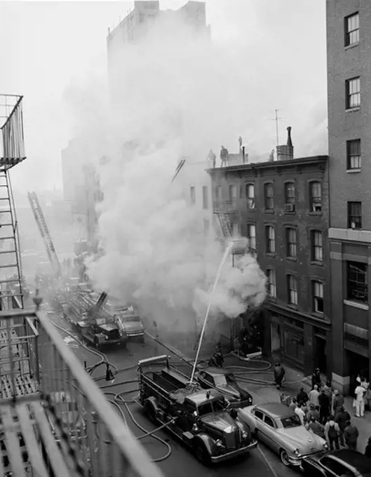 USA, New York State, New York City, Fire on East 47th Street, with fire engines shooting water on burning building