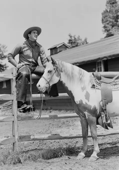 USA, Cowboy sitting on fence