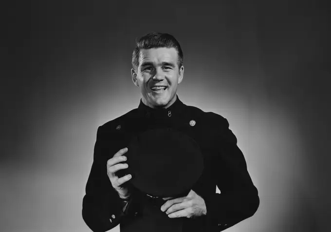 Portrait of mature smiling man in uniform, studio shot