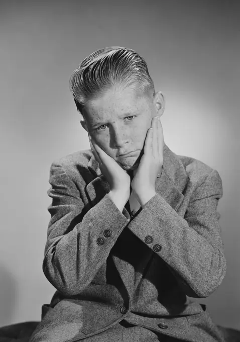 Portrait of worried teenage boy, studio shot