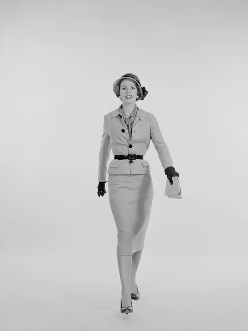 Portrait of elegant young woman walking, studio shot