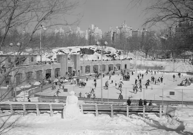 USA, New York State, New York City, Central Park, Wollman's Memorial, winter ice skating, Fifth Avenue skyline in background