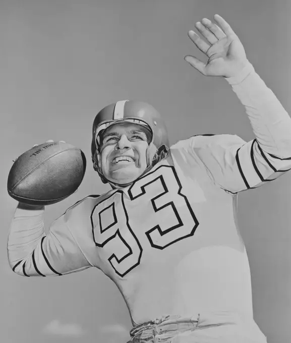 Mid adult American football player holding football