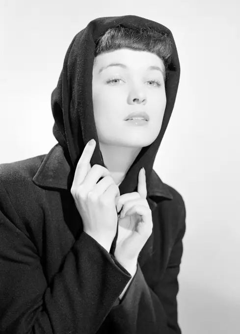 Studio portrait of young woman wearing hood