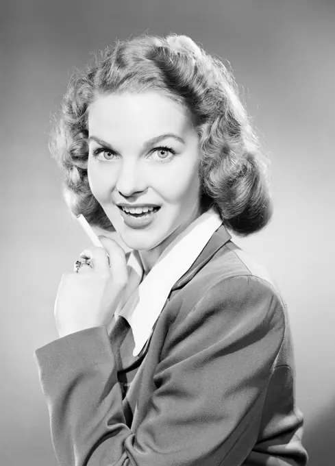 Studio portrait of young woman smoking cigarette