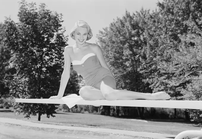 Portrait of young woman in swimming costume on diving board