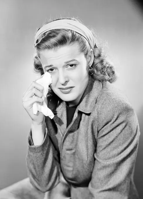 Studio portrait of young woman crying