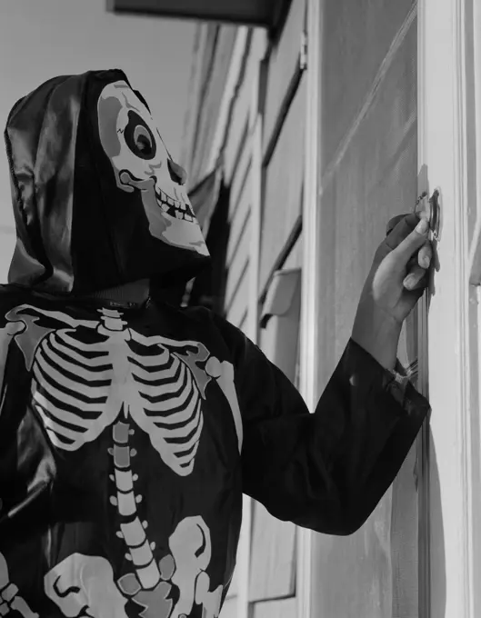 Person ringing doorbell wearing as skeleton